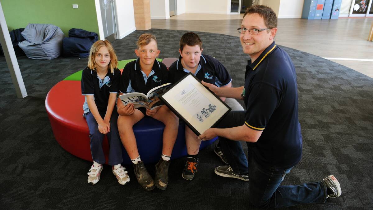WINNERS: Horsham Special School principal Matt Copping shows Bianca Williamson, Tyson Harris and Bailey McGennisken a state award for best new educational facility. The school will now compete nationally. Picture: PAUL CARRACHER