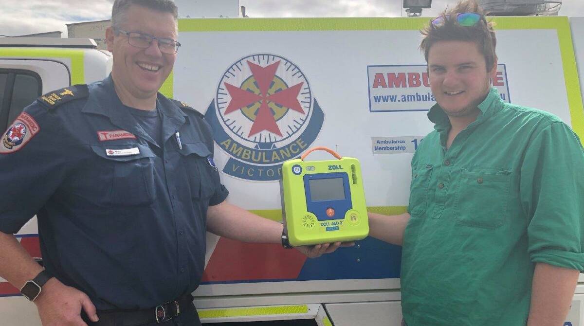 LIFE SAVER: Paramedic Matt Pearce with Riley Keel with one of the life saving AED's. Picture: CONTRIBUTED