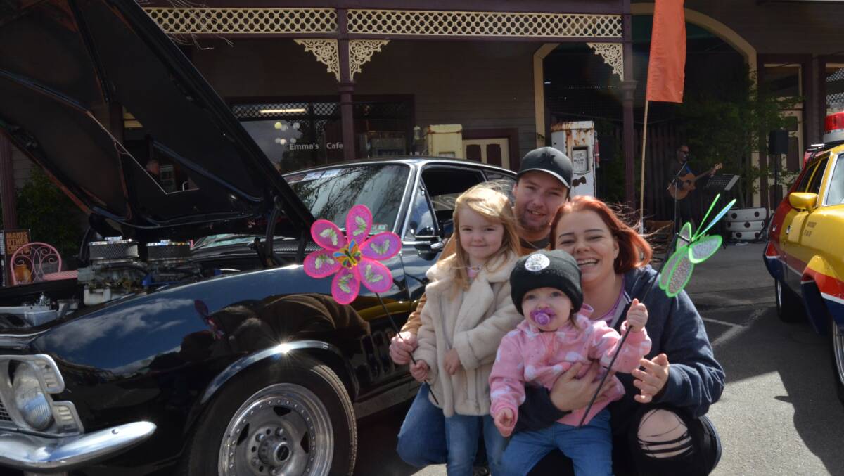 WEAPON: Ayla Sampson-Lyall 4, with her sister Amora, 4 with Dylan Sampson-Lyall and Mikayla Walsh infront of the "weapon", a Mad Max replica car. picture: ALISON FOLETTA.