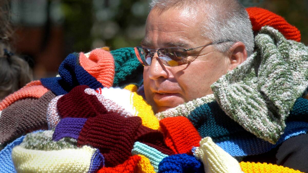COMMUNITY: Gary Bird wrapped in scarves knitted as part of a family violence awareness campaign. Picture: FILE