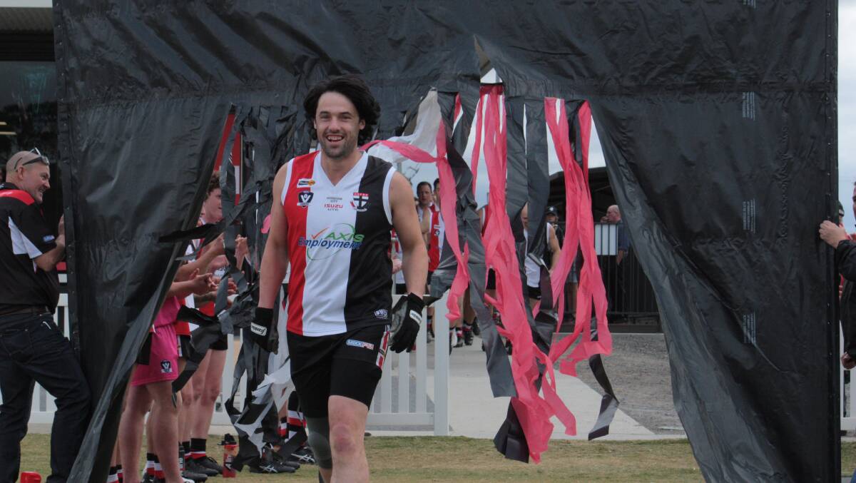 300 NOT OUT: Bowen Friend is all smiles walking through his 300th game banner for the Horsham Saints on Saturday. Picture: KRISTINE GRACE