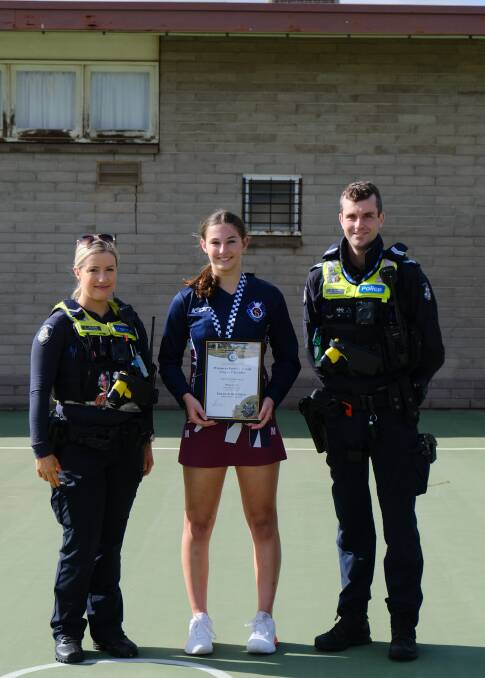 Bianca Carr photographed receiving her award at the Horsham Police Officers First Constable Laura Griffiths and Senior Constable Daniel Brody.