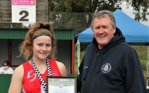 GUTSY: Kayla Kelm pictured receiving her award at the netball from Blue Ribbon Foundation Member Les Power at the Taylors Lake Netball Courts. 