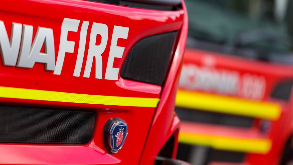Emergency services respond to grass fire threatening a shed