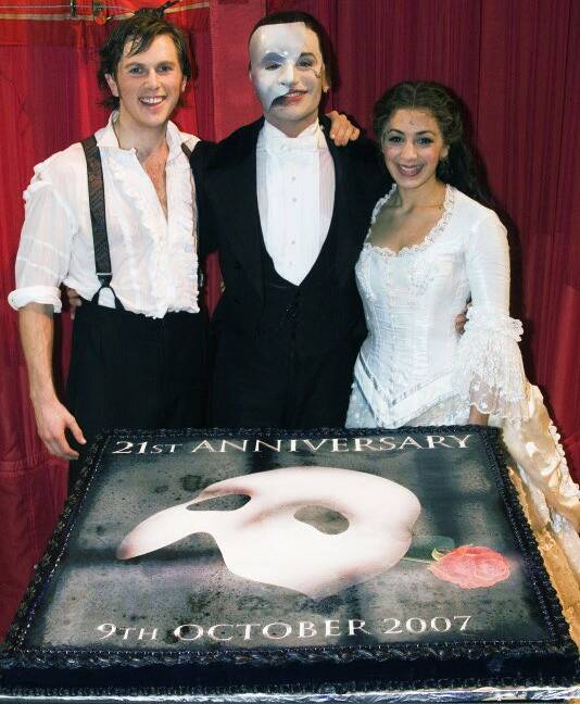 Alex Rathbeger on stage after the curtain call in London, 21st-anniversary cake for Phantom of the Opera with Ramin Karimloo and Leila Benn Harris. Picture by Dan Wooler.