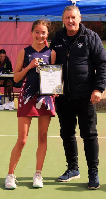 Horsham Demons netballer Sarah Miller is presented her Blue Ribbon Foundation Spirit of Netball award by foundation member Les Power. Picture supplied by Eliza McAnulty. 