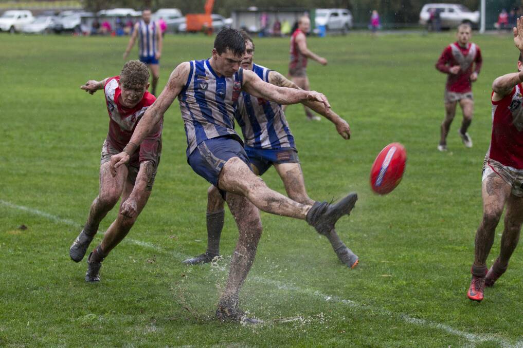 It was a wet day of sport on Saturday. Harrow-Balmoral player Cody Deutscher kicks through the puddles.