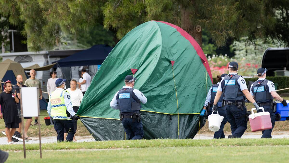 Police move camping equipment from the lake side of King Edward Terrace on Thursday. Picture: Sitthixay Ditthavong