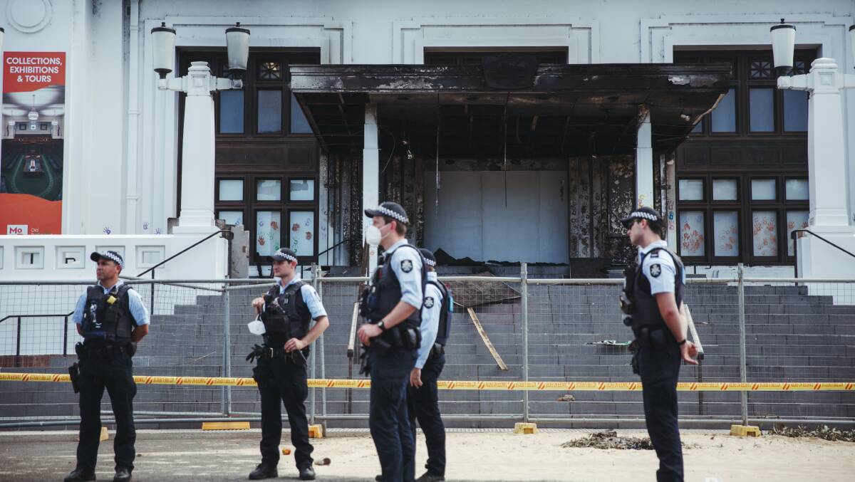 Police guard the front of Old Parliament House the day after violent protesters lit a fire which severely damaged the building's front portico. Picture: Dion Georgopoulos