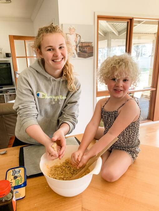 Imogen, 16, and Molly, 5, try home economics while remote learning. Pictures: BIANCA DICKINSON