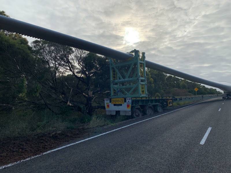The rear of the trailer carrying the 82-metre long wind turbine blade has gone off the road surface and become stuck.