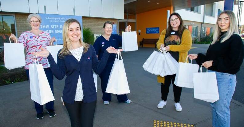 Queanbeyan hospital midwives Jacqui Daniels, maternity unit manager, Amanda Sibley and Jess Mifsud receive donations from The Lab Skincare Clinic co-owner Tegan Williams and skincare specialist Hannah Corcoran. Photo: Elesa Kurtz.