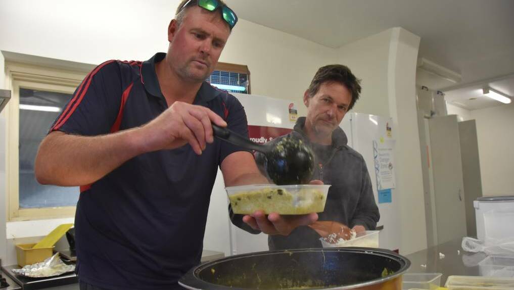 Mark Blight and Todd McShane serving up chicken curry to serve to people on Sunday evening.