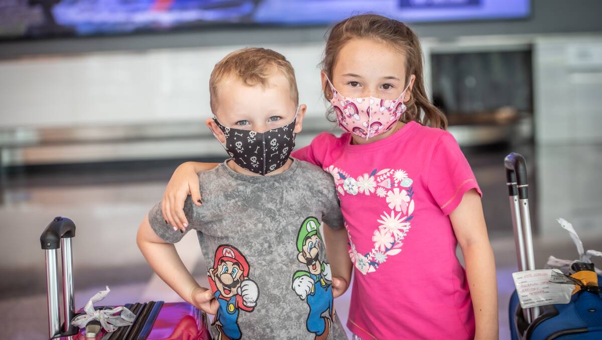 NEW RULES: Austin, 5, and Evie Matthews, 7, wearing masks at Canberra Airport on Friday after returning home. Masks are now mandatory on all flights. Picture: Karleen Minney