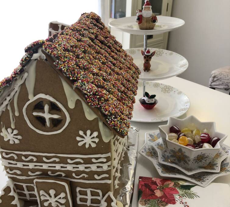 CENTEREPIECE: The gingerbread house is ready for the Christmas Eve grazing table after its construction took a team effort. 