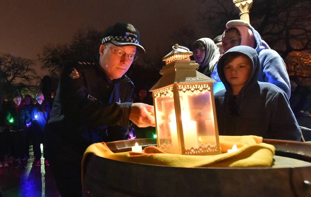 HOPE: Ballarat police Inspector Trevor Cornwill lights a candle in the annual Out of Shadows walk in Ballarat last year.