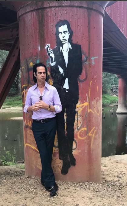 Reconciled: Nick Cave in January with his likeness on a pillar of the railway bridge across the Ovens River at Wangaratta. Picture: KRISTENA GLADMAN