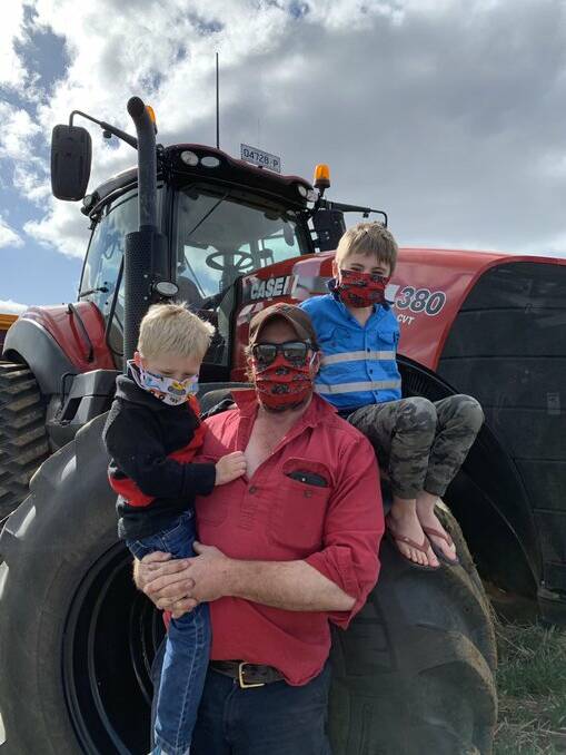 SIGN OF THE TIMES: Minyip farmer Ryan Milgate, centre, took this photo to put towards the #masksonfarm campaign. Picture: CONTRIBUTED