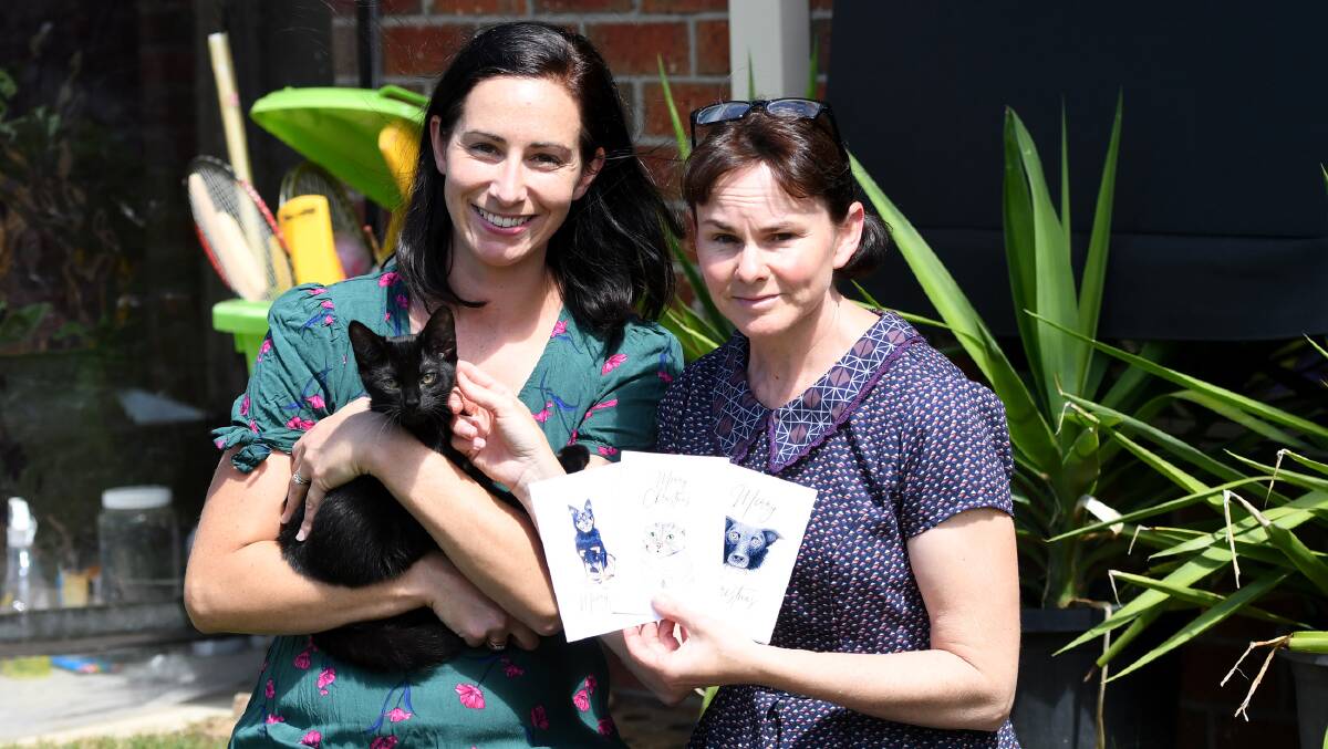 ANIMAL ATTRACTION: Horsham Paws secretary Kristy Kelly, and illustrator Becky McCoy, with new Horsham Paws Christmas Cards, and Jamie, the kitten. Jamie, a boy, is 14-weeks old and up for adoption.