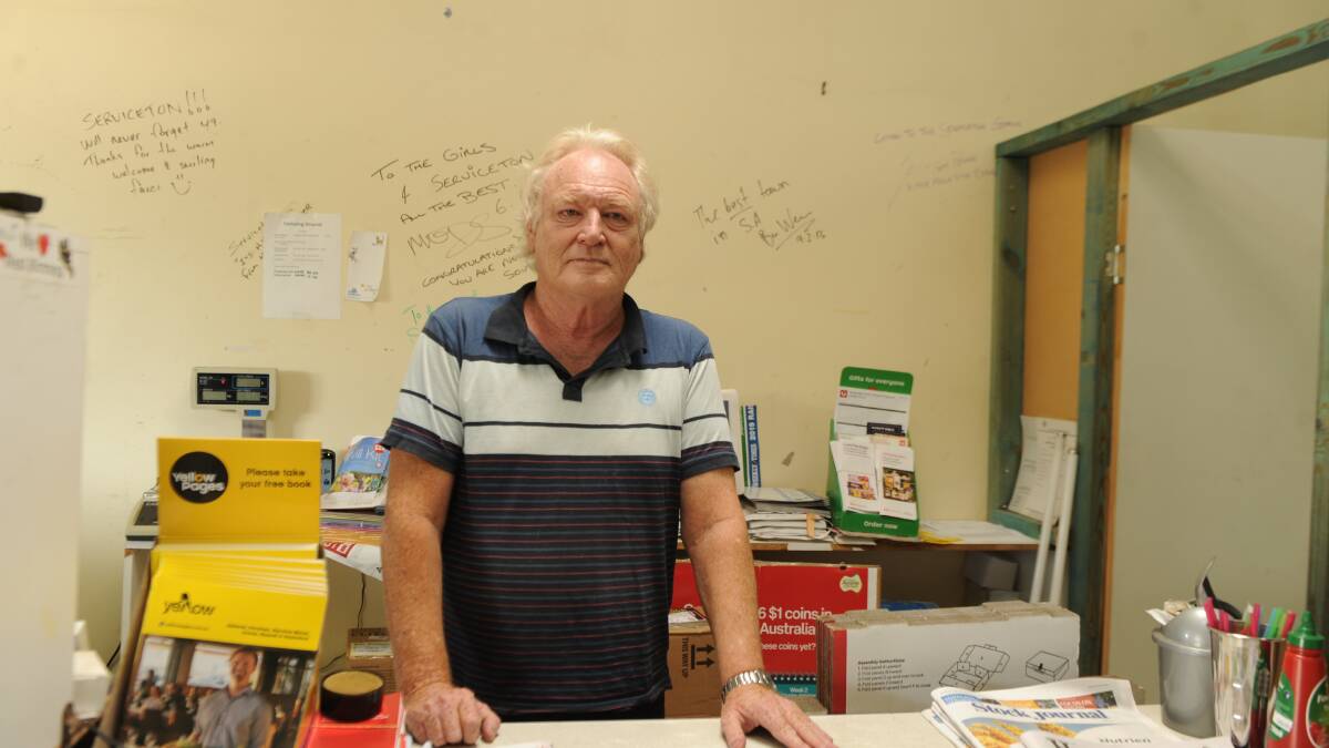 HISTORY IN THESE WALLS: Serviceton General Store owner Ron Roy with autographs on the shop walls from AFL legend Tony Modra and others who came to the town to film a beer ad in 2013. Picture: ELIZA BERLAGE