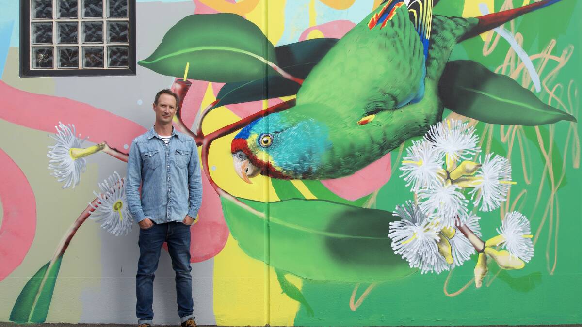PAST WORK: Artist Geoffrey Carran with a mural he painted in Bendigo. Picture: ROWENA MARTINICH