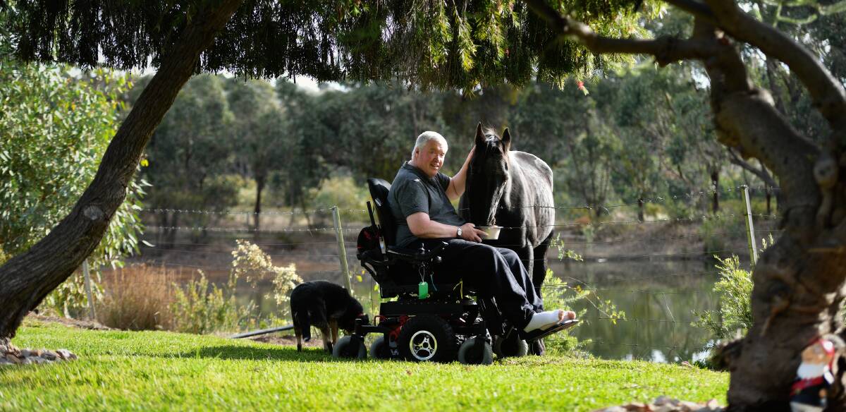 AWARENESS: Rod Case is raising awareness for MND. He thanks his loving support system which includes his wife, his dog and horse. Picture: DARREN JAMES 