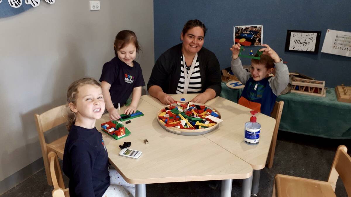 Happy times: Kalkee Road Kindergarten pupils Harriet Holmes (left), Chloe Sevenich and Freddy Sproule (pictured with teacher Lisa Williams) are delighted to be at kindergarten. During Term 3 the Victorian government will pay for half of the children's fees. Picture: SUPPLIED