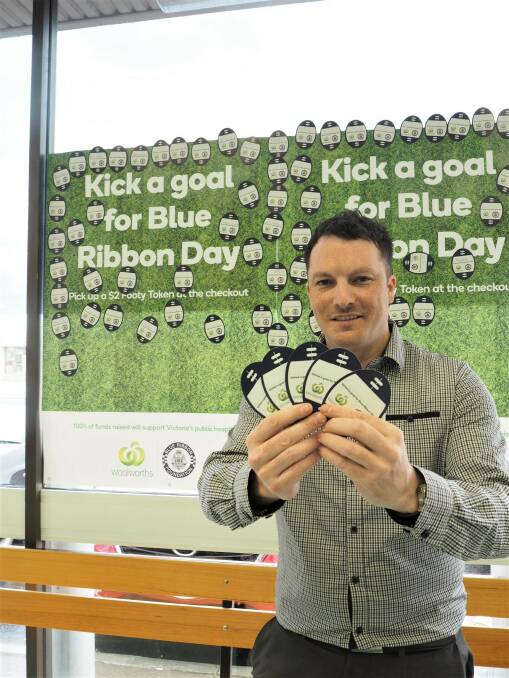 FUNDRAISING: Woolworths Horsham store manager Mick Eltze holding football-shaped tokens that will be displayed on the supermarket wall. Picture: DAINA OLIVER