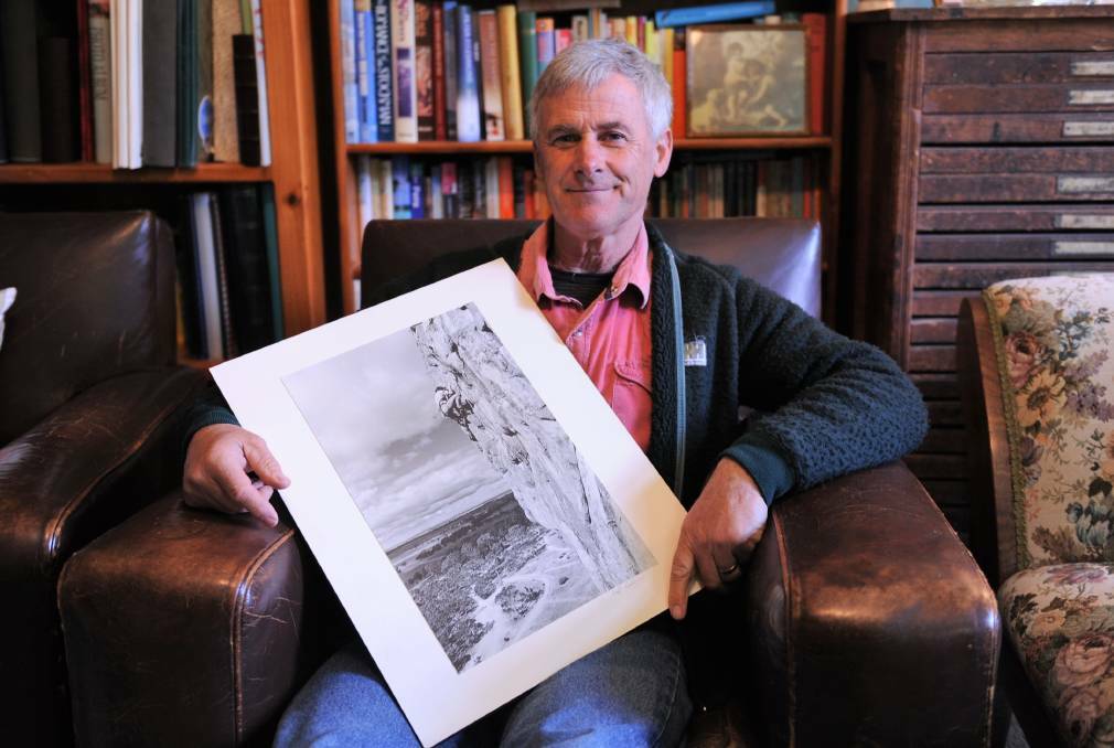 EXPERIENCE: Natimuk resident Keith Lockwood with a photo of himself climbing Mt Arapiles in the 1970s. Mr Lockwood has been a rock climber for more than 50 years. Picture: JADE BATE