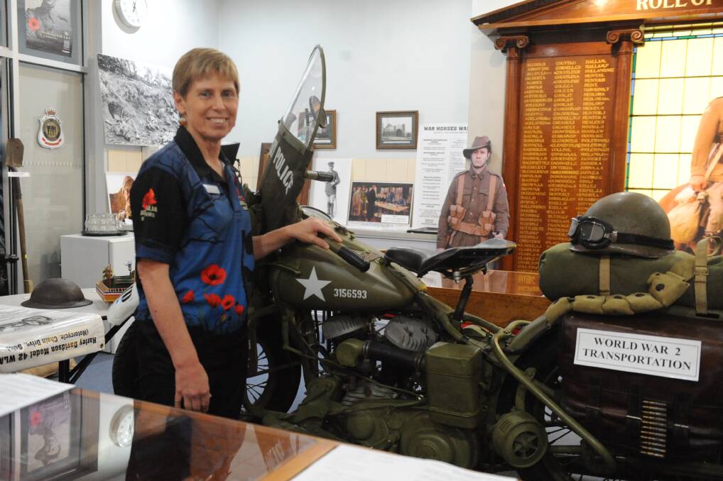 MEMORABILIA: Horsham RSL military history and heritage volunteer Sally Bertram with a World War II Harley Davidson motorcycle on display at the military exhibition.