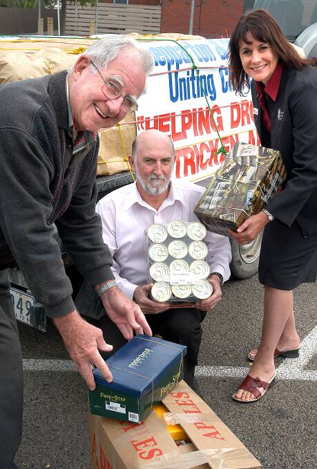 St Davids Uniting Church Shepparton Stewart Russell presents drought relief parcels to Christian Emergency Food Centre's John Parker and Wimmera Uniting Care's Sue Frankham in 2005.