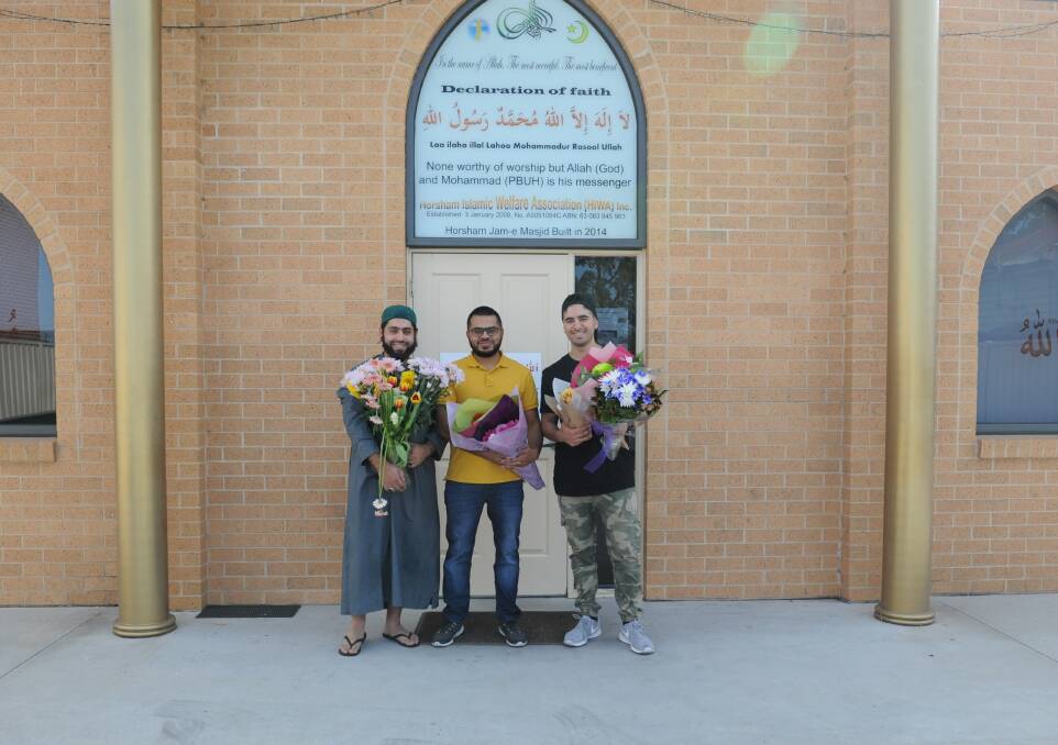 Horsham's Ozi Kocak, Rameez Malik and Firat Aytar with the flowers sent to the mosque in support for the Islamic community. Picture: DAINA OLIVER