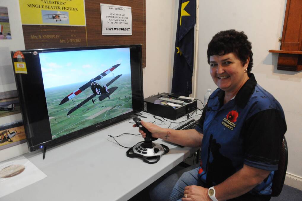 FLYING: Horsham RSL military history and heritage secretary Jacci Pirout on the flight simulator at the military exhibition. 