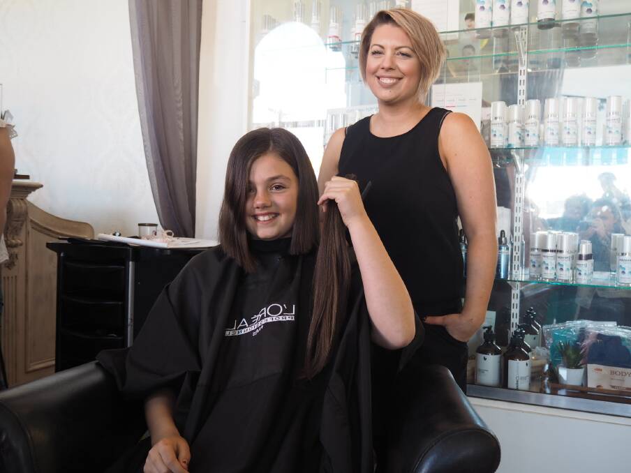 CHOPPED: Ella Officer holds her chopped hair that Sassi Beauty Bar's Kara Dingwall cut for her to mark the end of Ella's fundraising campaign. Picture: DAINA OLIVER