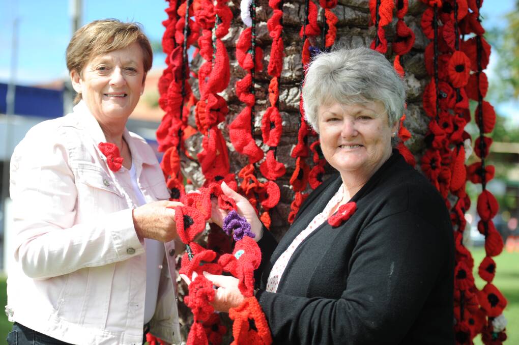 PAYING RESPECTS: Pam Deckert and Rosie Clark with some of the 20,000 crocheted poppies on display in Nhill's Goldsworthy Park to pay tribute to those who served in World War One and World War Two. Picture: ELIZA BERLAGE
