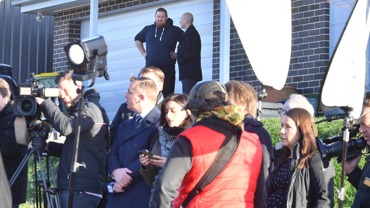 The proud Googong homeowner (top left) during the media conference outside his home on Thursday morning. Picture: AAP
