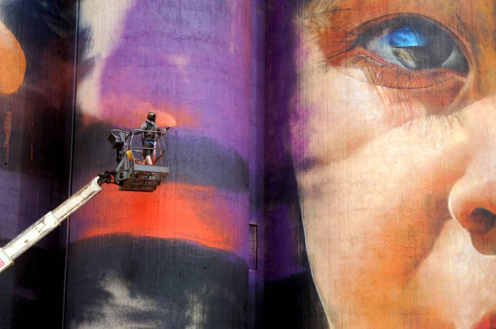ATTRACTION: Artist Adnate paints the Sheep Hills silo, one of six across northern Victoria that is driving tourists to the region as part of the Silo Art Trail. 