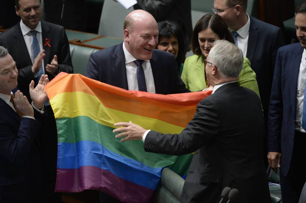 JUBILANT: Prime Minister Malcolm Turnbull, right, moves to embrace Member for North Sydney Trent Zimmerman after the same-sex marriage bill passed in parliament. Picture: NICK MOIR