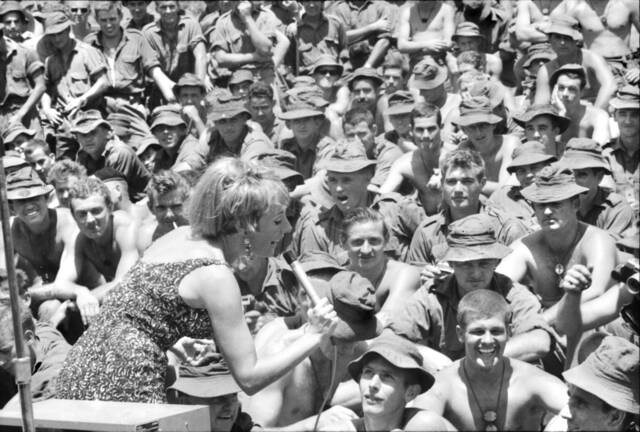 Lorrae Desmond sings to the troops in Vietnam in 1967, with Norm Austin in the centre of the shot, and fellow Mittagong RSL member Phill Moscatt at centre right. Photo: Australian War Memorial/public domain