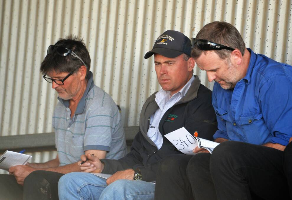 Naracoorte agent Simon Mulraney with clients, Peter Irving who was the biggest volume buyer with 25 rams (average $1184) and Glen Sambell. Picture: CONTRIBUTED
