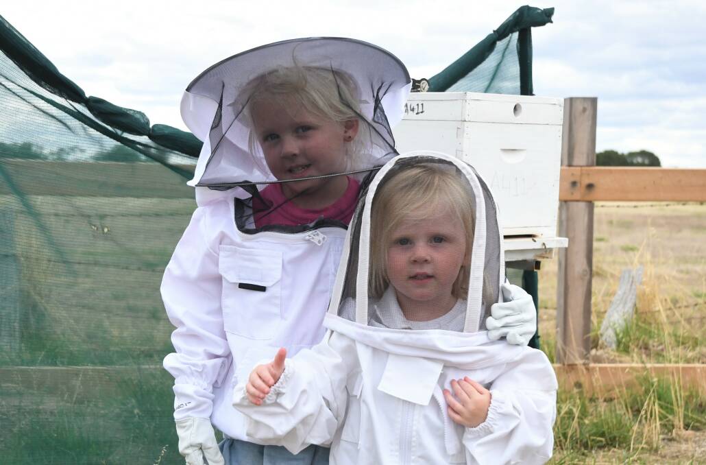 FAMILY FUN: Dimboola siblings Bindi and Tully Abbott help their mum Sandy Abbott keep bees behind their house. Picture: JADE BATE