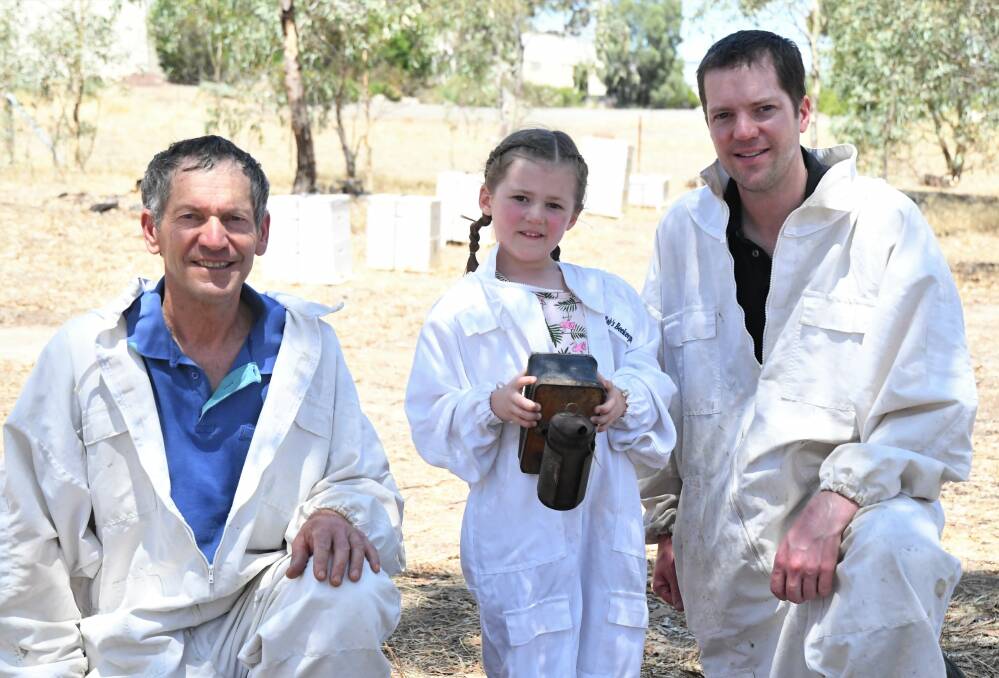 FAMILY: Lucy Mathews, 5, (centre) has been helping her grandpa Andrew Mathews and dad Greg Mathews tend bees at Laharum's Grampians Olive Co. Picture: JADE BATE