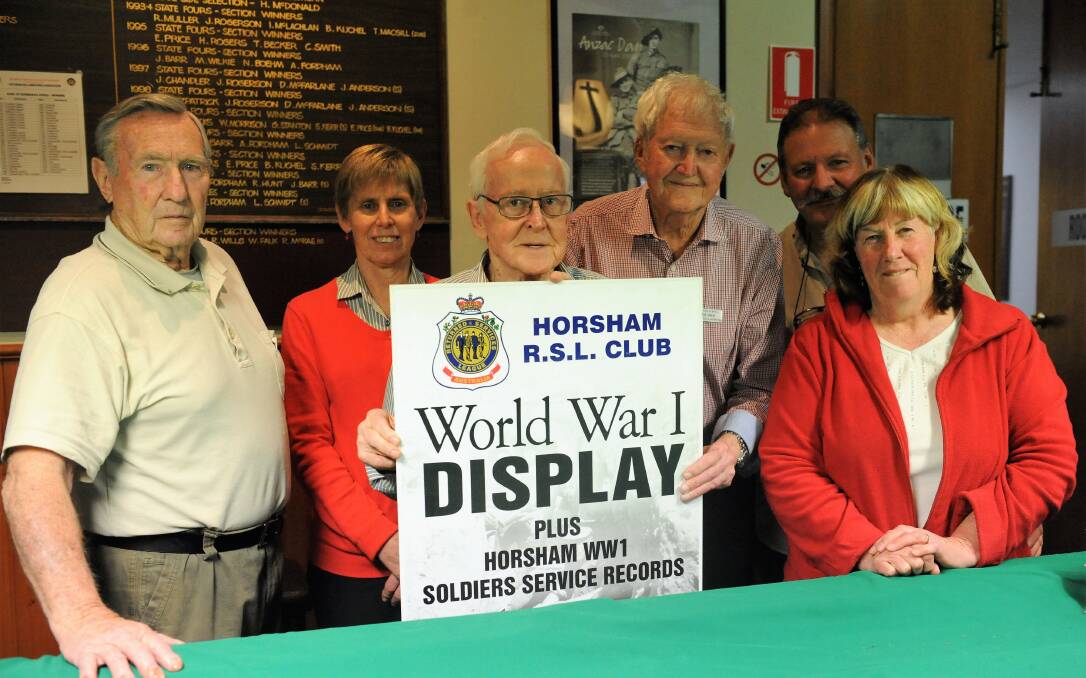 HISTORY REMEMBERED: Horsham RSL military history team members with a sign promoting their exhibition to commemorate the end of the First World War. Picture: CARLY WERNER