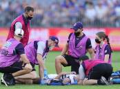 NERVOUS MOMENTS: Rebels product Darcy Tucker receives medical treatment after collapsing to the ground during Fremantle's win. Picture: Getty Images