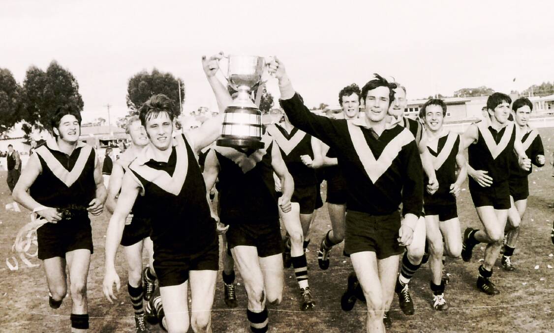SWEET SUCCESS: Nhill's 1969 premiership side proudly hoist the cup during the post-match celebrations at Horsham. Nhill won 19 consecutive matches on their way to the flag, defeating Stawell in the grand final. 