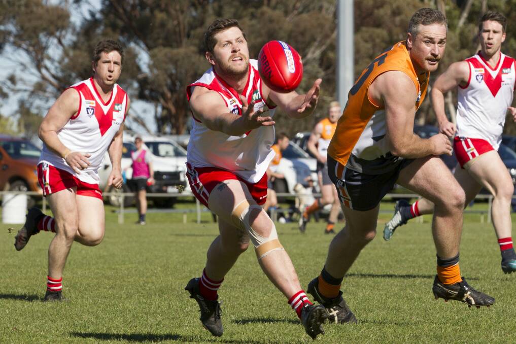 Ryan Bates is at full stretch as he attempts to drag the ball in during this season's qualifying final. Following closely is Southern Mallee Giants forward Riley Lehmann. Picture: PETER PICKERING
