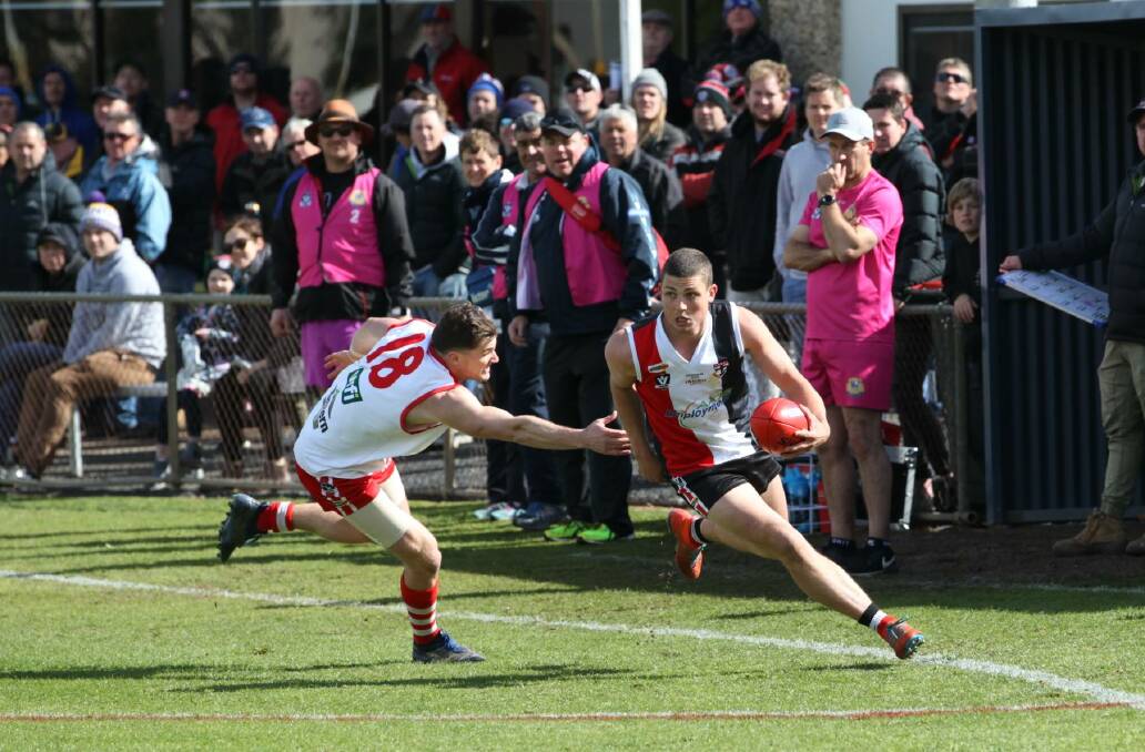 A packed crowd watches Horsham Saints' Sam Jasper streak down the wing. Picture: PETER PICKERING