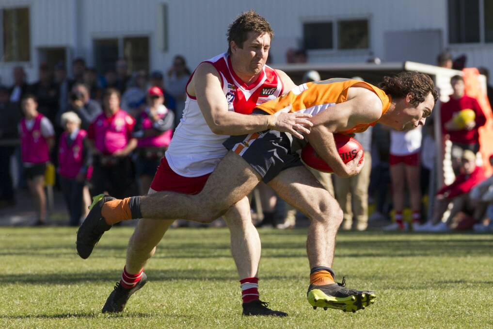 Lou White is tackled in the qualifying final. Picture: PETER PICKERING
