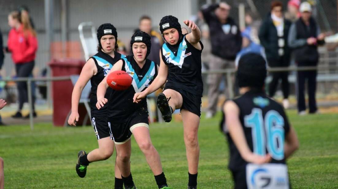 A young Swifts player kicks long. Picture: KARL MEYER