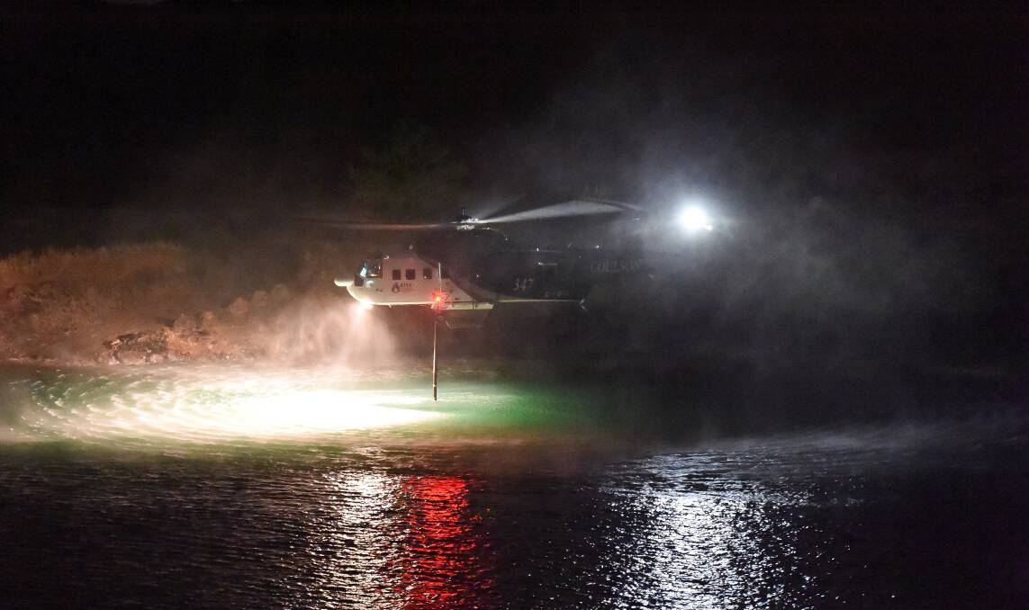 TRIAL: Crews hover above a dam to take on water during night firefighting trials last summer. Picture: Emergency Services Victoria